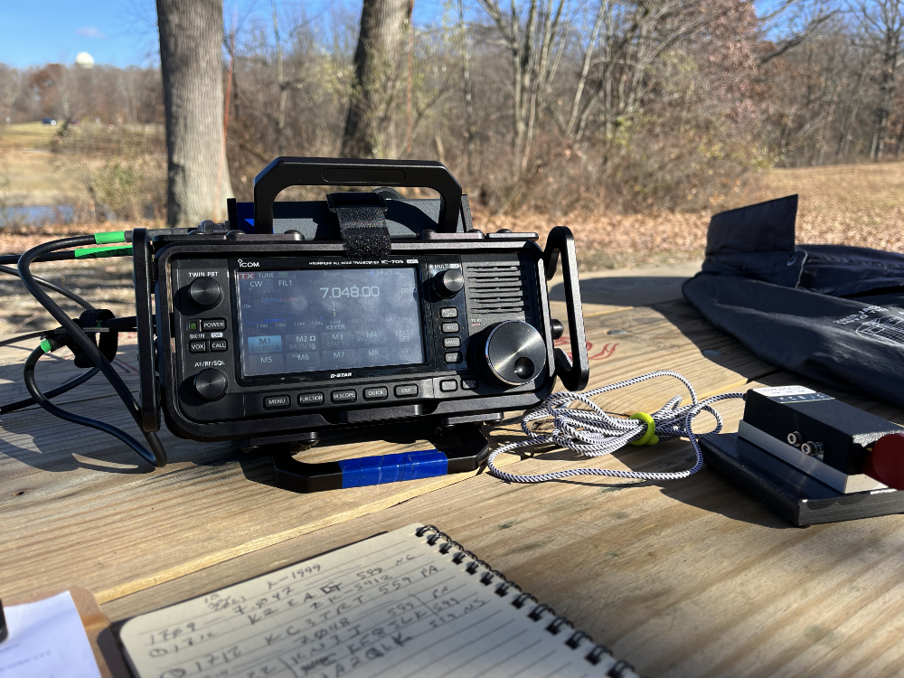 IC-705, log book, and paddles on a picnic table.
