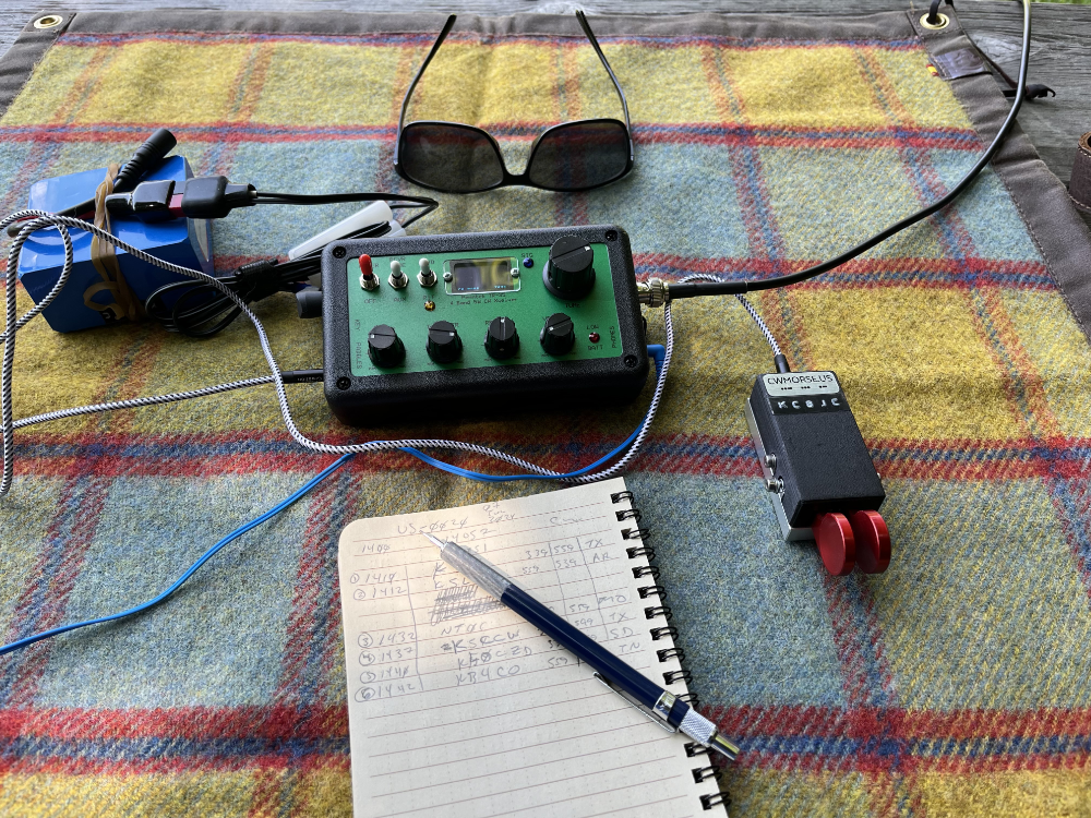 Battery, TR-35, sunglasses, log book, and paddles on a tarp.