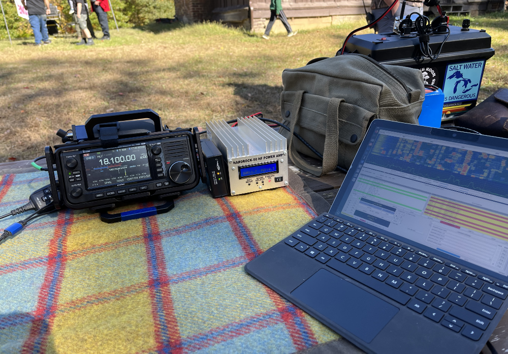 IC-705, Hardrock-50, and Surface Go 2 on a picnic table next to a battery box and a bag of gear. The Zumspot is visible on the battery box.