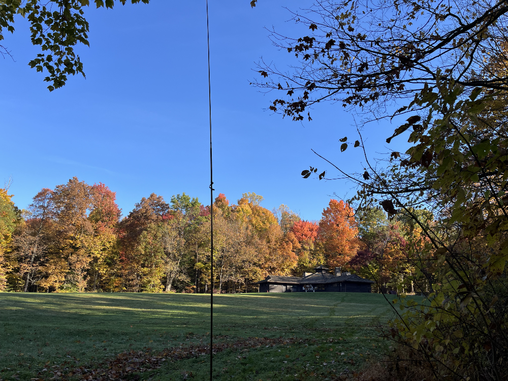 My antenna in the foreground with the Octagon shelter and colorful trees behind it across the field.