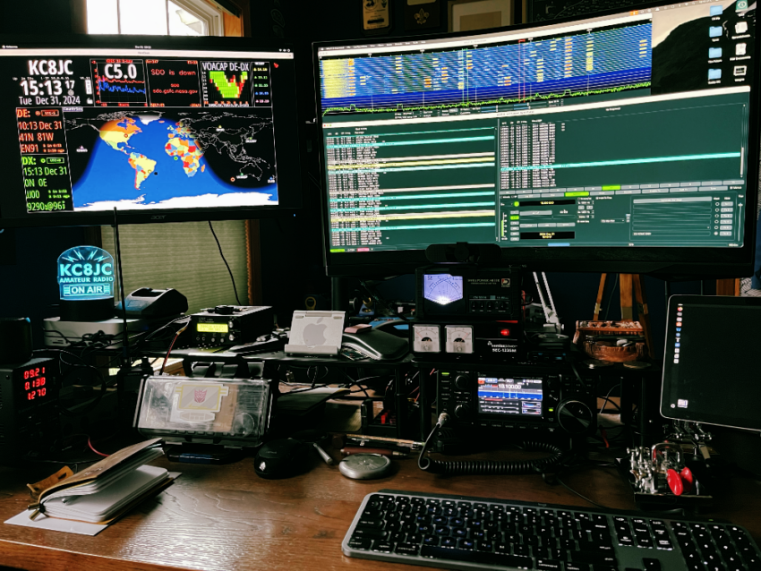 The desk of KC8JC complete with computer monitors and various radios.