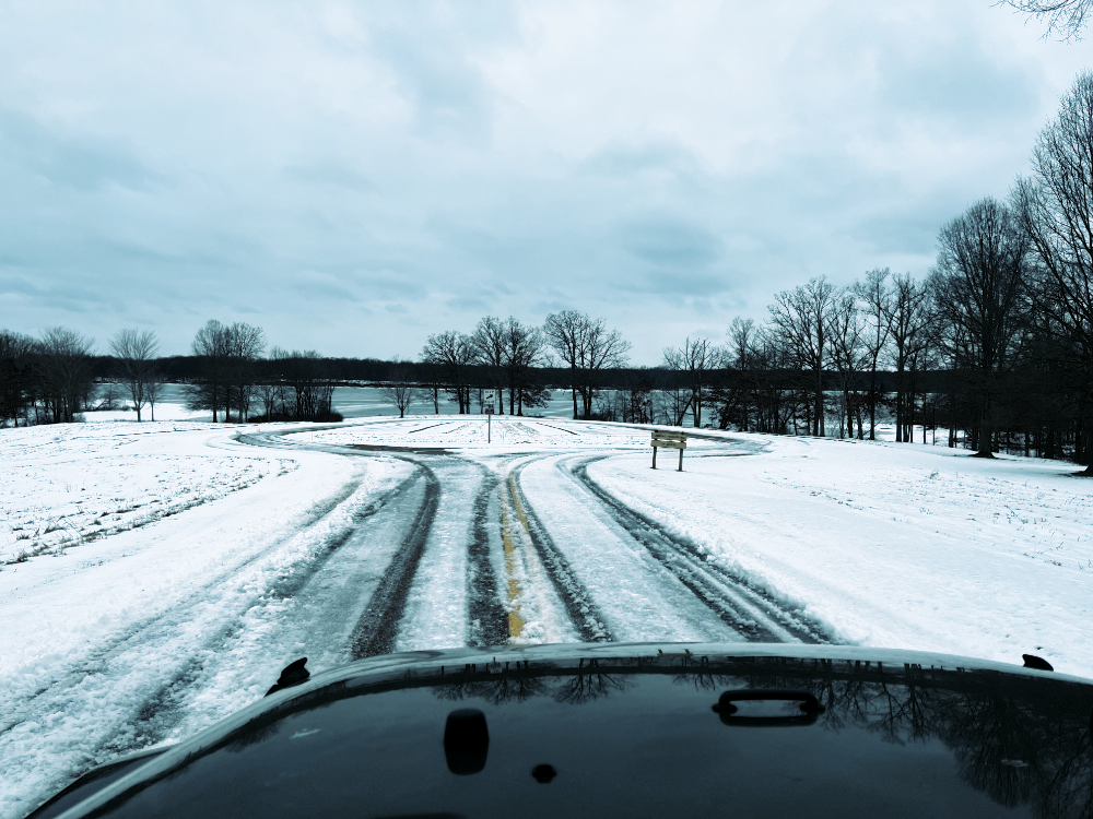 The view of the empty parking lot and frozen reservoir beyond from over the hood of the Jeep as I approach.