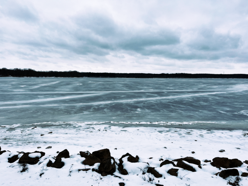 A view of the frozen reservoir at West Branch State Park in Ohio from the rocky shore.